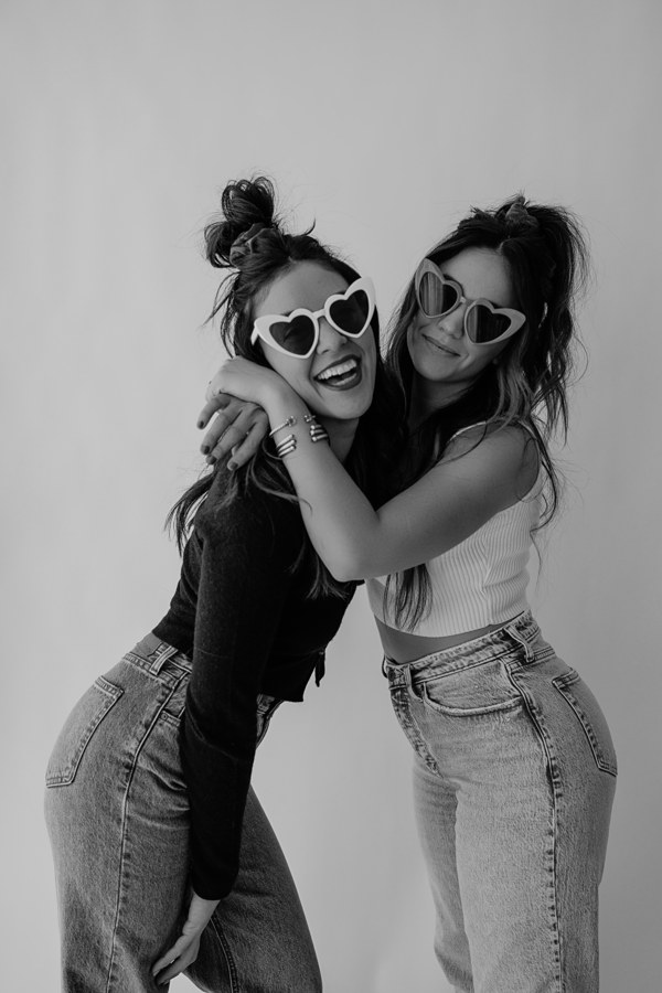 Em and Lu hugging in heart sunglasses